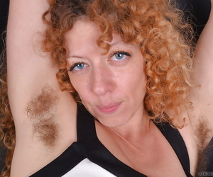 Mature redhead with small tits showing off hairy underarms and vagina
