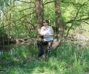 Mature amateur Mary Bitch exposes her tits and snatch near a river