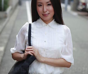 Japanese schoolgirl Anna Sakura pauses in the street to..