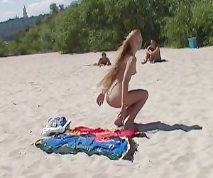 看 一个 赤裸裸的 小妞 在 的 海滩 tan 她的 热 身体