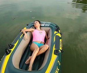 European teen with a flawless body relaxes in a small boat..