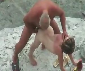 Camra gets old guy banging young girl on the beach